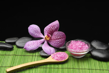 Fototapeta na wymiar Różowa sól w łyżka z różowa orchidea na macie zielonego