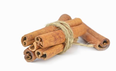 A bundle of cinnamon sticks tied together on white background