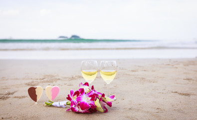 Романтический символ любви. Цветы и вино на песчаном пляже.