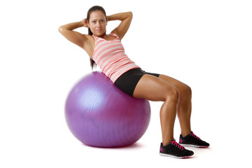 Young woman doing situps on ball