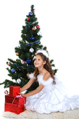 Little beautiful girl near a christmas tree isolated on a white 