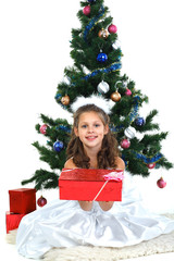 Little beautiful girl near a christmas tree isolated on a white 