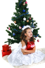 Little beautiful girl near a christmas tree isolated on a white 