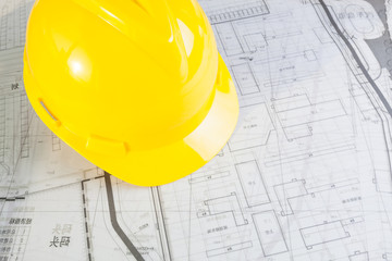 Construction plans with yellow helmet
