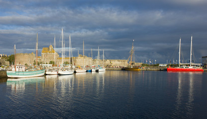 Fototapeta premium yachts in harbor of Saint Malo, France, old town under storm cou