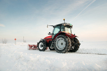 Tractor cleaning snow