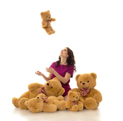 brunette woman posing in luxurious dress playing with teddy bear