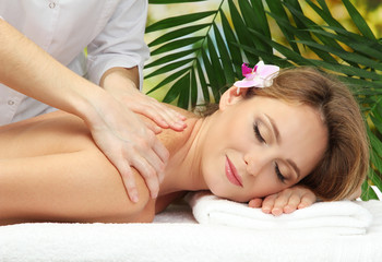 Obraz na płótnie Canvas beautiful woman in spa salon getting massage,