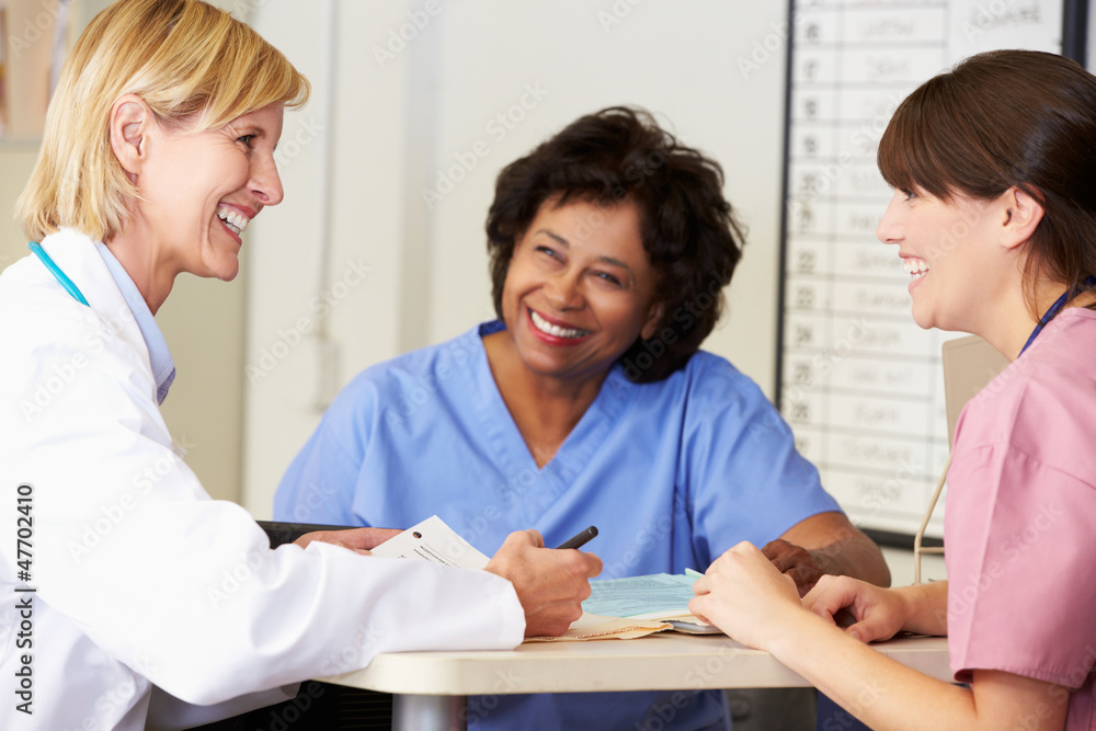 Wall mural doctor and nurses in discussion at nurses station