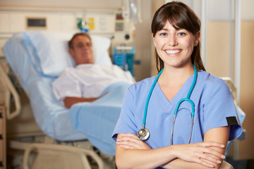 Portrait Of Nurse With Patient In Background