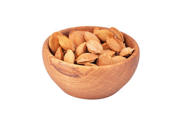 Apricot stone in wooden bowl on white background