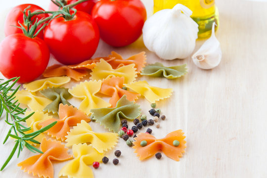 Ingredients for Italian cuisine: farfalle pasta, tomatoes, olive