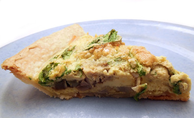 Slice of quiche with artichoke and arugula