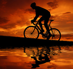 Fototapeta premium silhouette of the cyclist riding a road bike