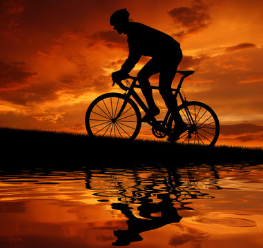 silhouette of the cyclist riding a road bike