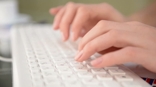 Woman typing on white keyboard