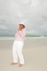 Fototapeta na wymiar Mature woman active retirement storm beach isolated