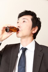 スタミナドリンクを飲むビジネスマン