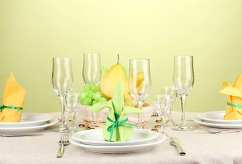 Table setting in green and yellow tones on color  background