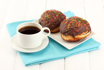 Tasty donuts on color plate on light wooden background