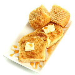 White bread toast with honey on plate, isolated on white