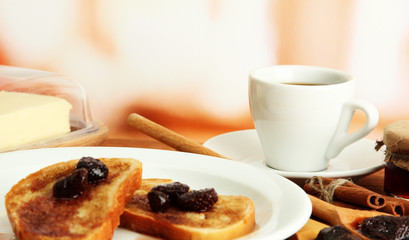 White bread toast with jam and cup of coffee on wooden table