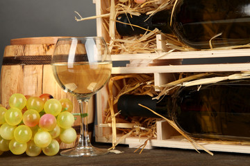Fototapeta na wymiar Drewniany przypadku butelki, wina beczki, lampki i winogron