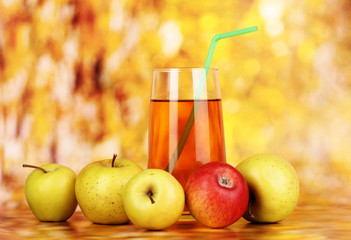 Useful apple juice with apples around on autumn background