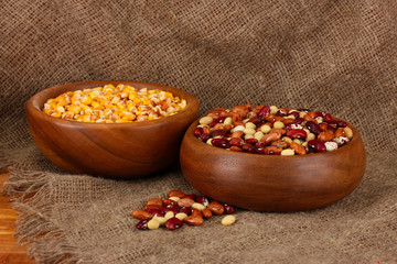 Raw corn, and beans in wooden bowls