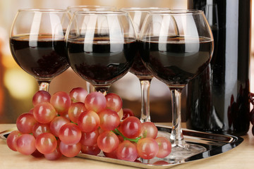 Red wine in glass and bottle on room background