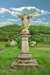 Fototapeta na wymiar statue of jesus in rural landscape