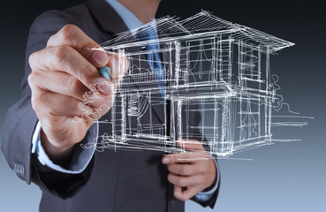 businessman hand drawing house in a whiteboard