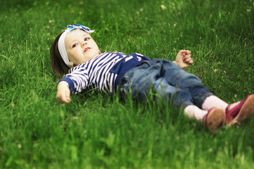 little funny girl lying in grass
