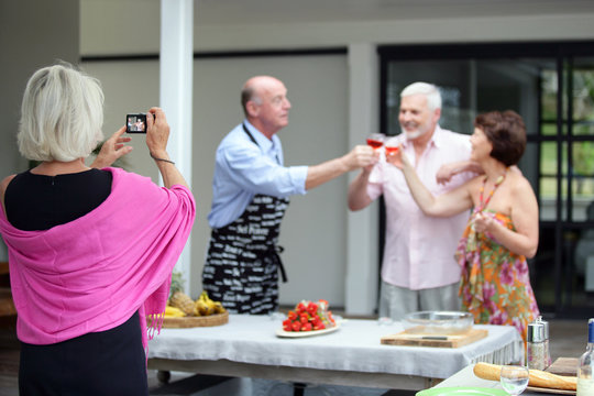 Older woman taking a photo at a party