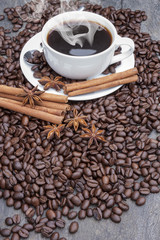 Steaming hot coffee with cinnamon sticks and star anise surround