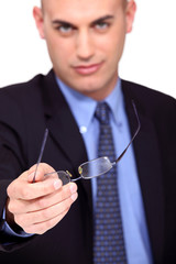 Businessman offering his glasses