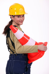 Female builder holding traffic cone