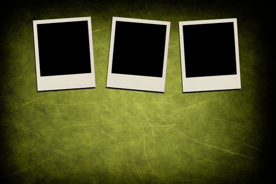 Blank instant photo frames on grunge green background