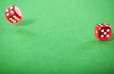 Rolling red dice on a casino table 
