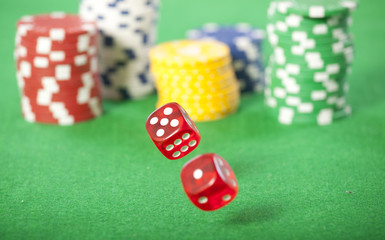 Rolling red dice on a casino table with chips 