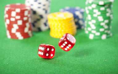 Rolling red dice on a casino table with chips 