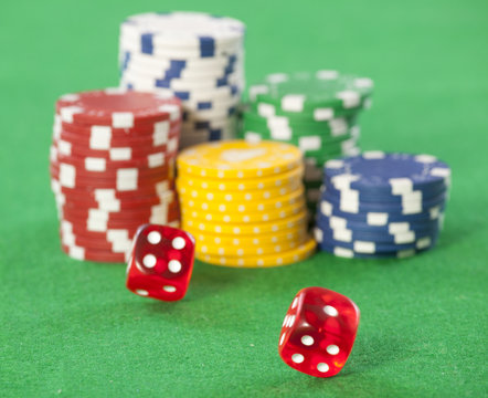 Rolling red dice on a casino table with chips 