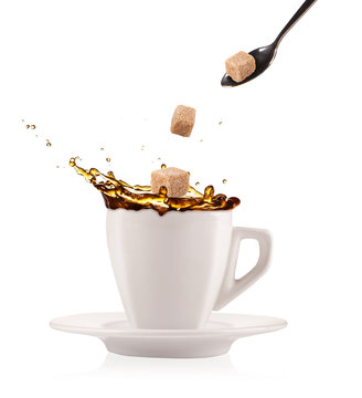 Coffee splashing out of cup with flying sugar cubes