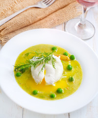 Fresh soup from green peas and egg-poached