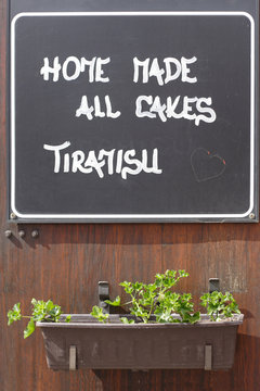 sign board at restaurant wall with a flowers in the box