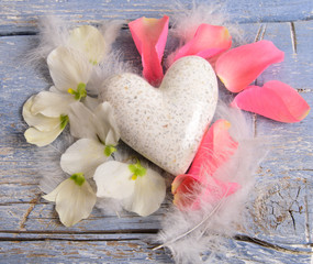Valentinstag: Herz mit Rosenblütenblättern und Federn
