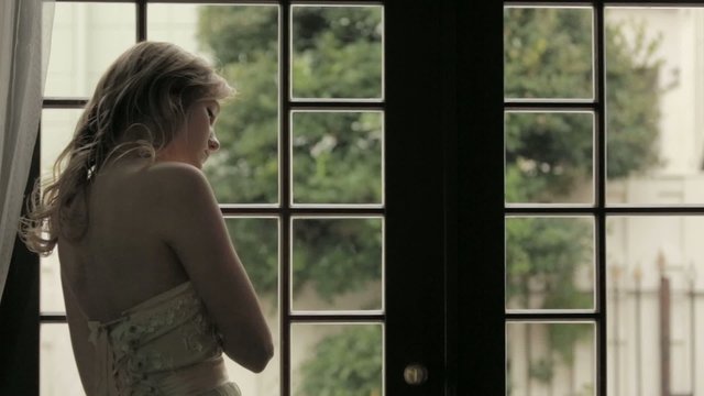 窓辺で悲しむ女性