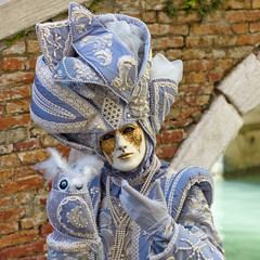 Person in Venetian costume attends Carnival of Venice.