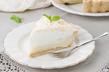 piece of lemon tart with meringue decorated with fresh mint