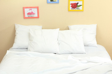 Empty bed with pillows and sheets in bedroom